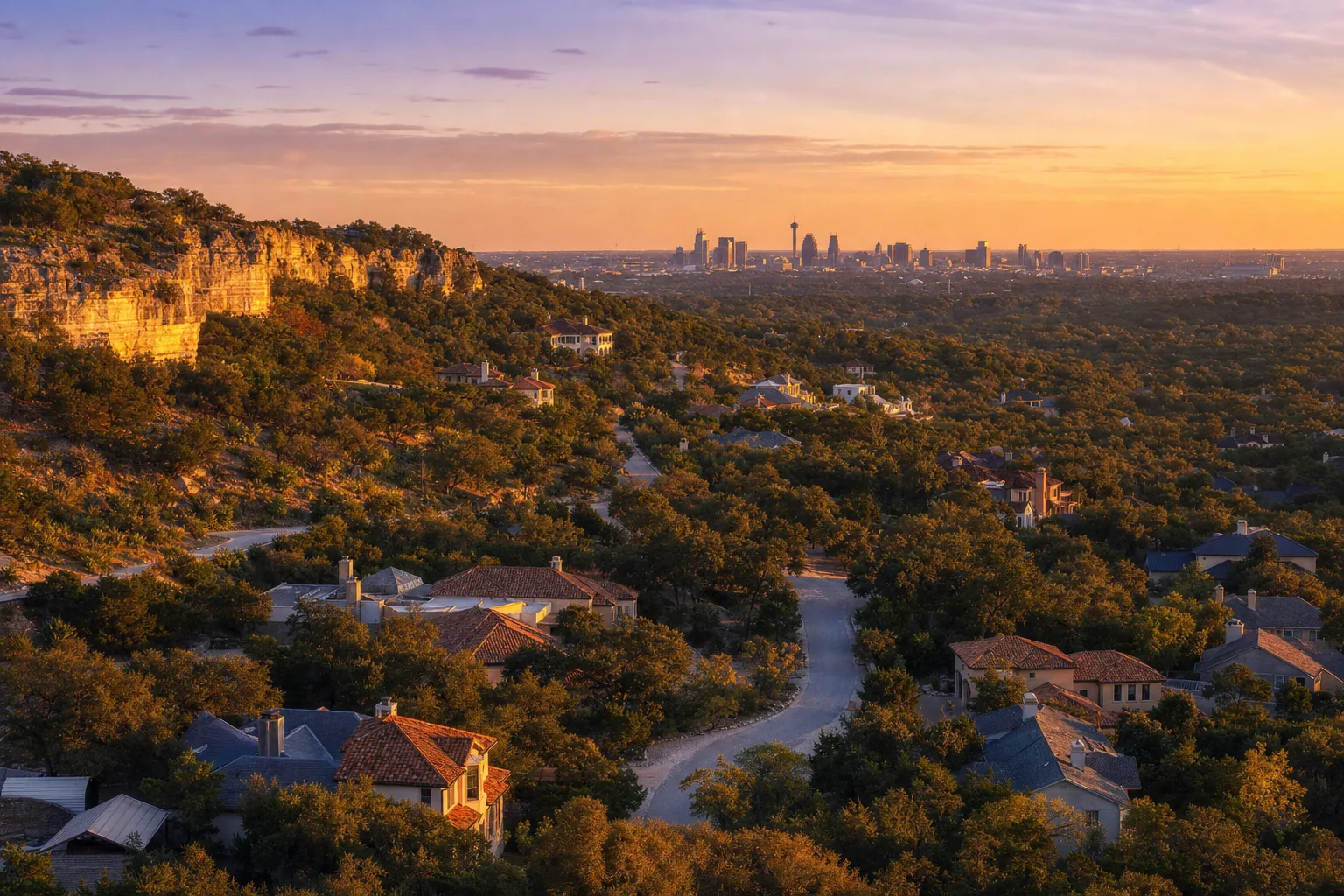 Aerial view of a San Antonio hillside neighborhood at golden hour with the downtown skyline in the distance